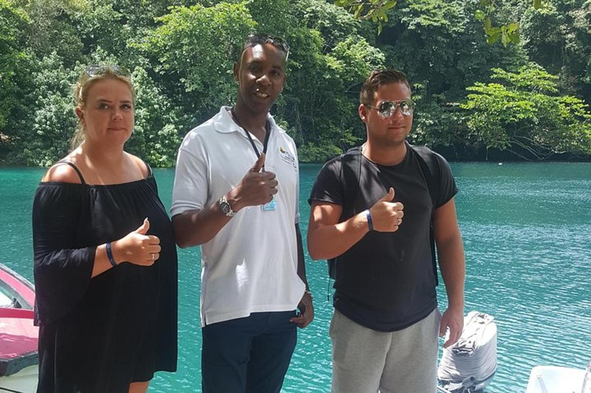 dva muži a žena stojící vedle vodní plochy