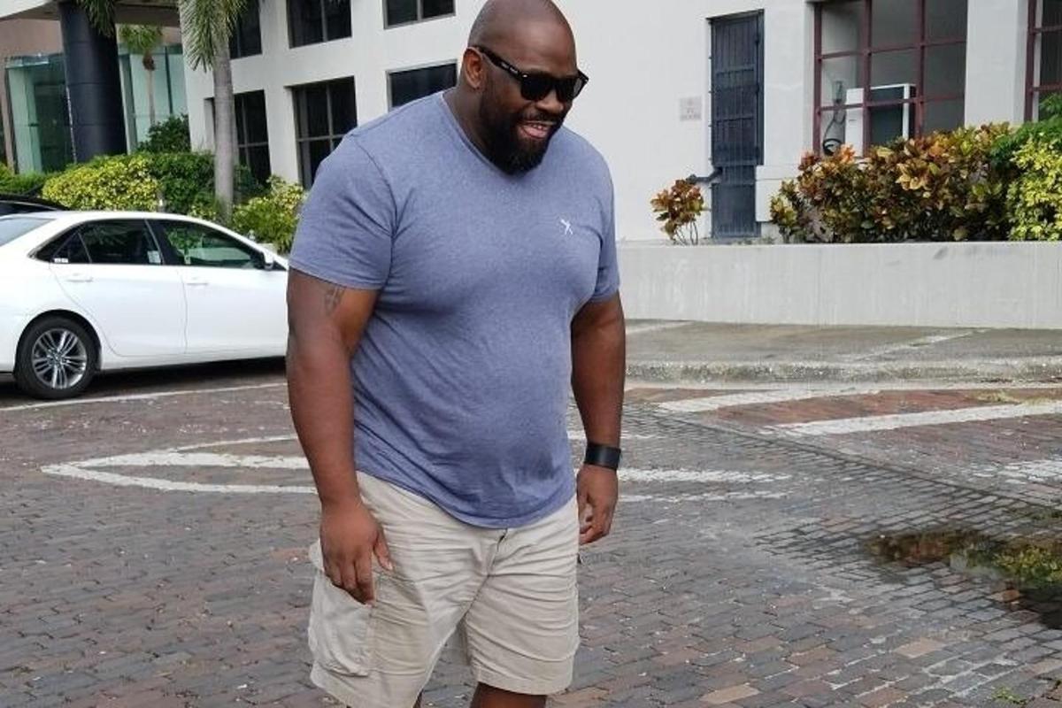 a man in a blue shirt standing on a street