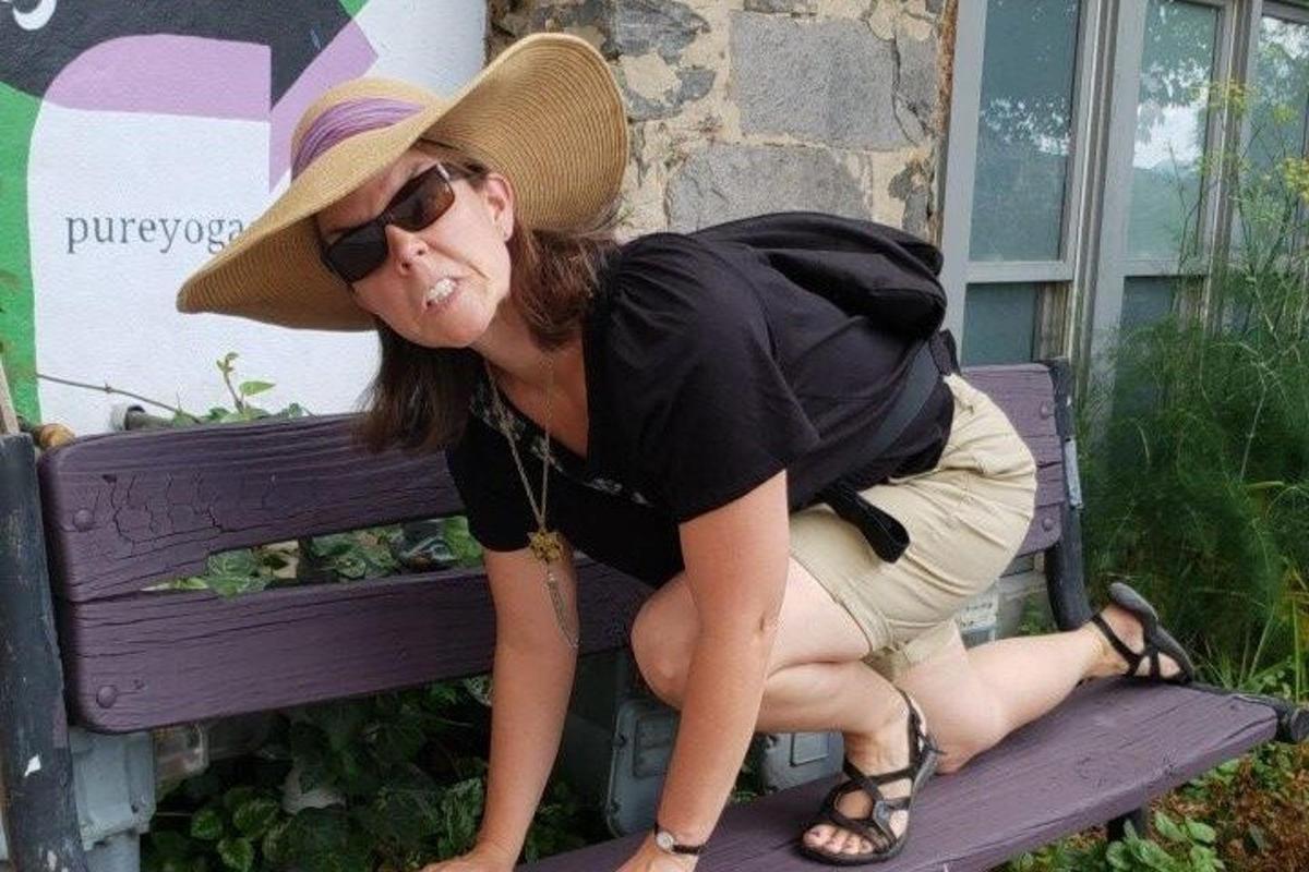 a woman wearing a hat sitting on a bench