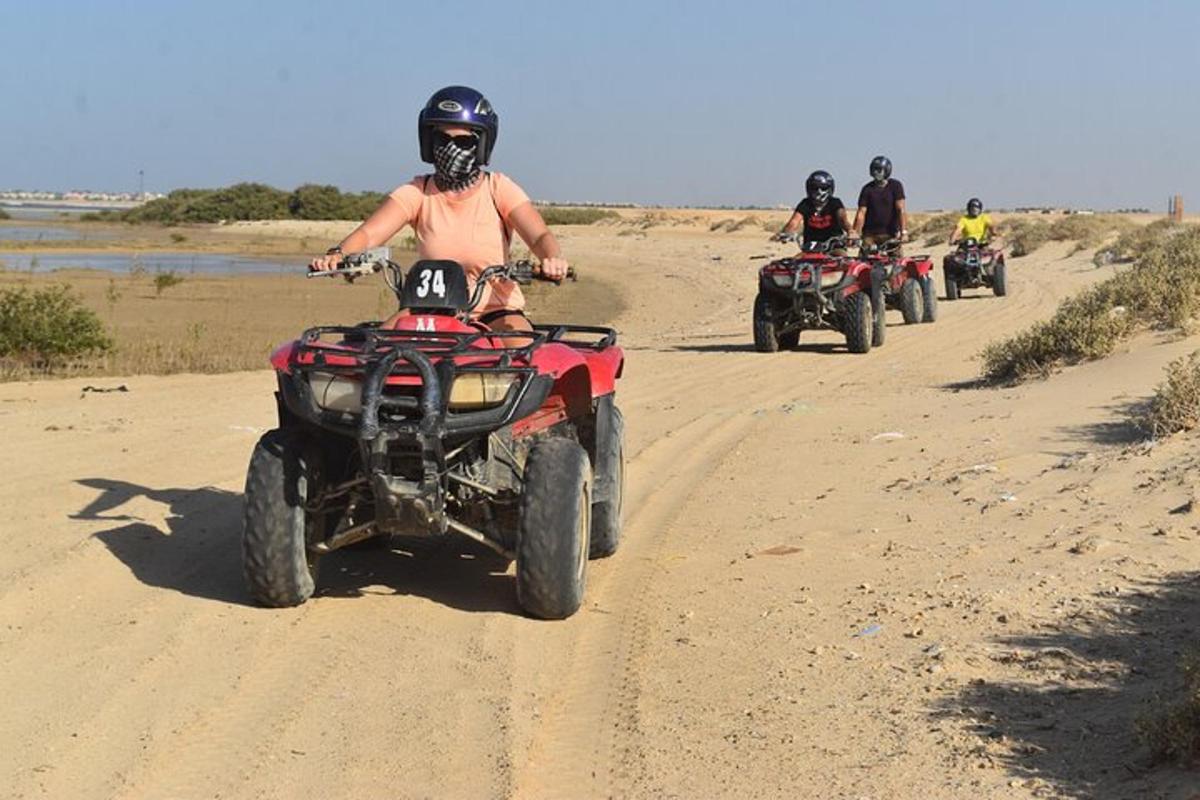 en gruppe mennesker som kjører ATV på en grusvei