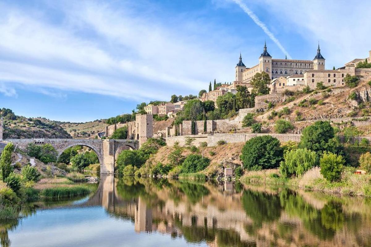un castello su una collina con un fiume e un ponte
