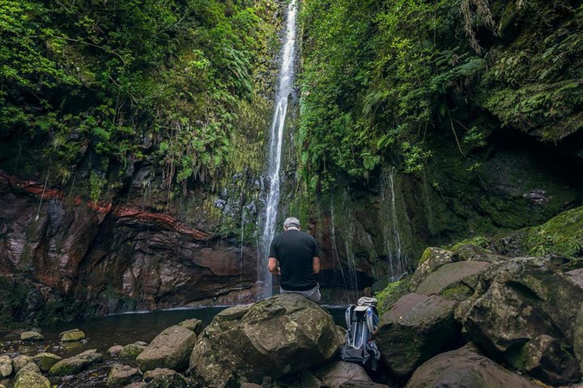 un uomo in piedi davanti a una cascata