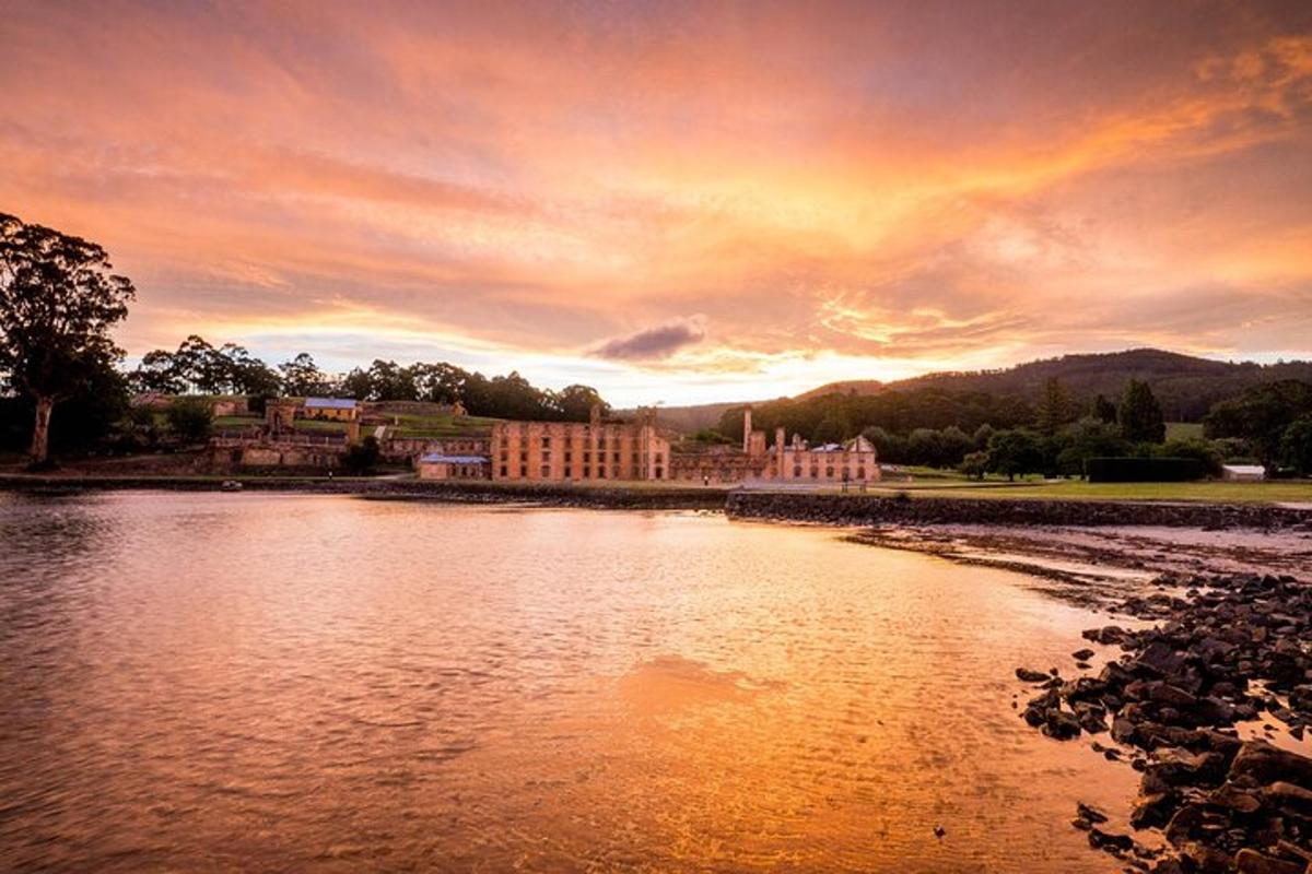 a sunset over a river in front of a building