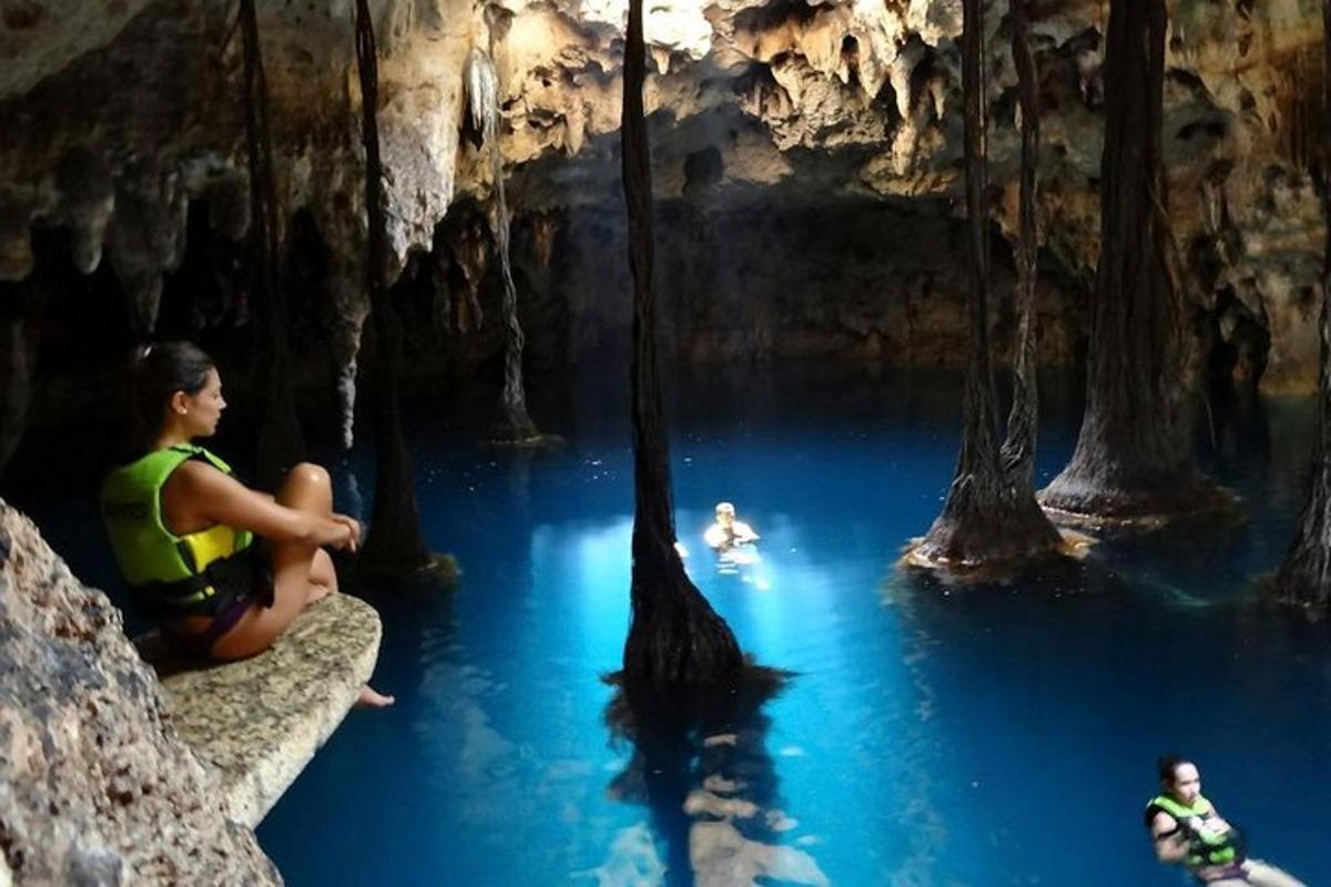 sekelompok orang yang duduk di kolam air di dalam gua