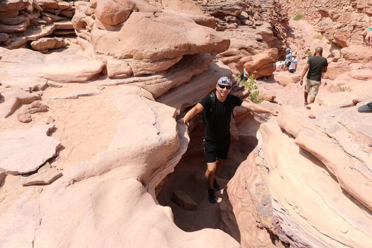 a man walking through a canyon in the desert