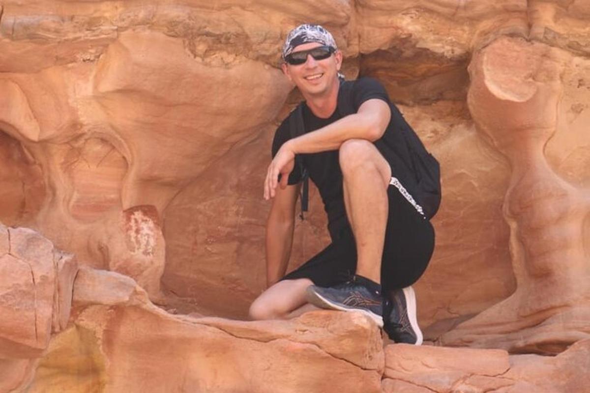 a man sitting on a rock in a canyon