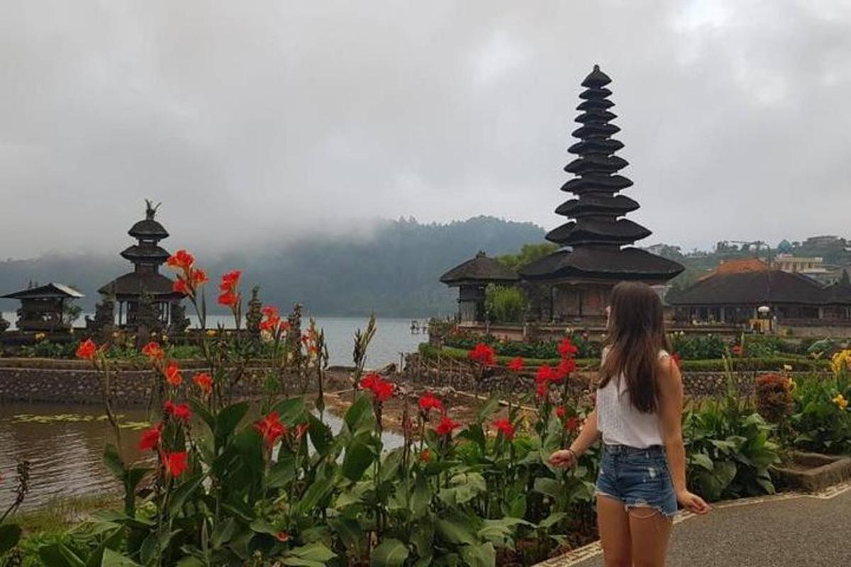 uma mulher caminhando em frente a um jardim com flores