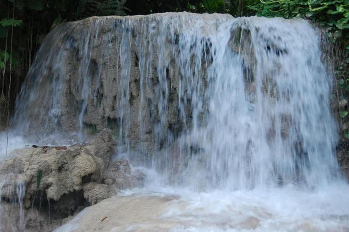 a waterfall with water falling off of a rock