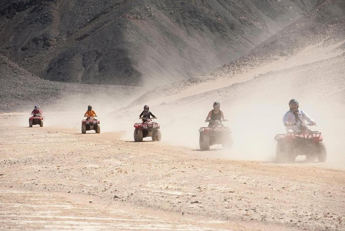 cilvēku grupa, kas brauc ar motocikliem pa netīru ceļu