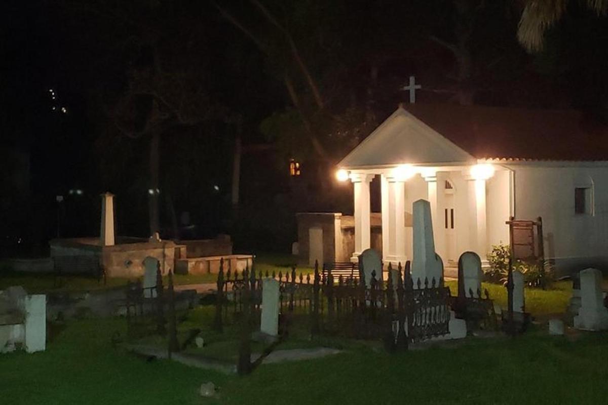 a church with a cross and a cemetery at night
