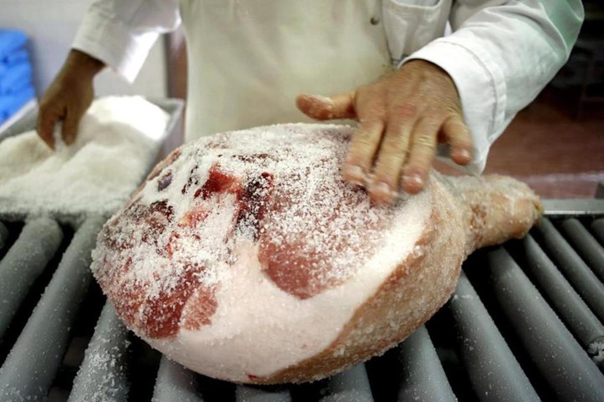 a man is holding a large piece of bread on a grill
