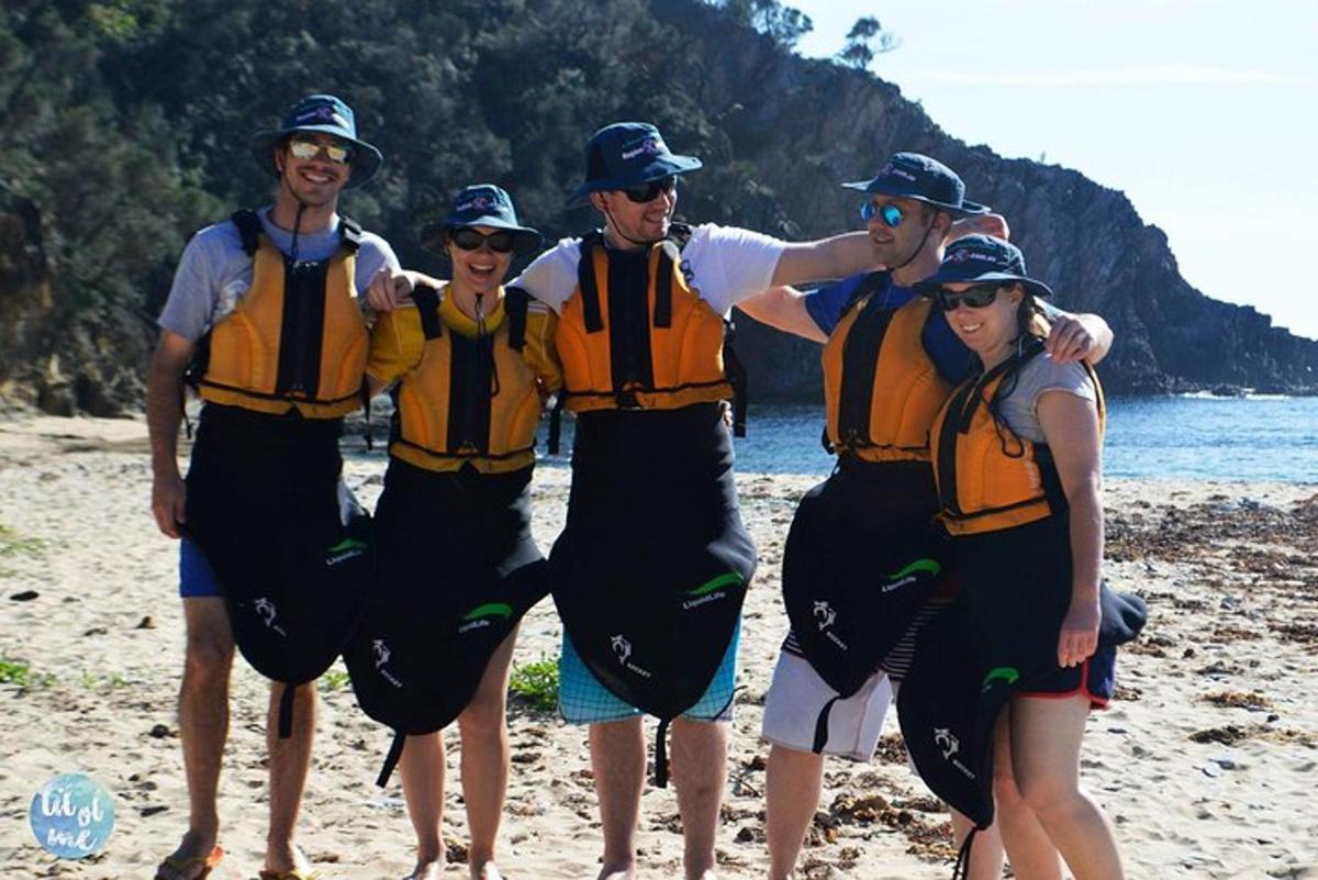 a group of people wearing life jackets on a beach