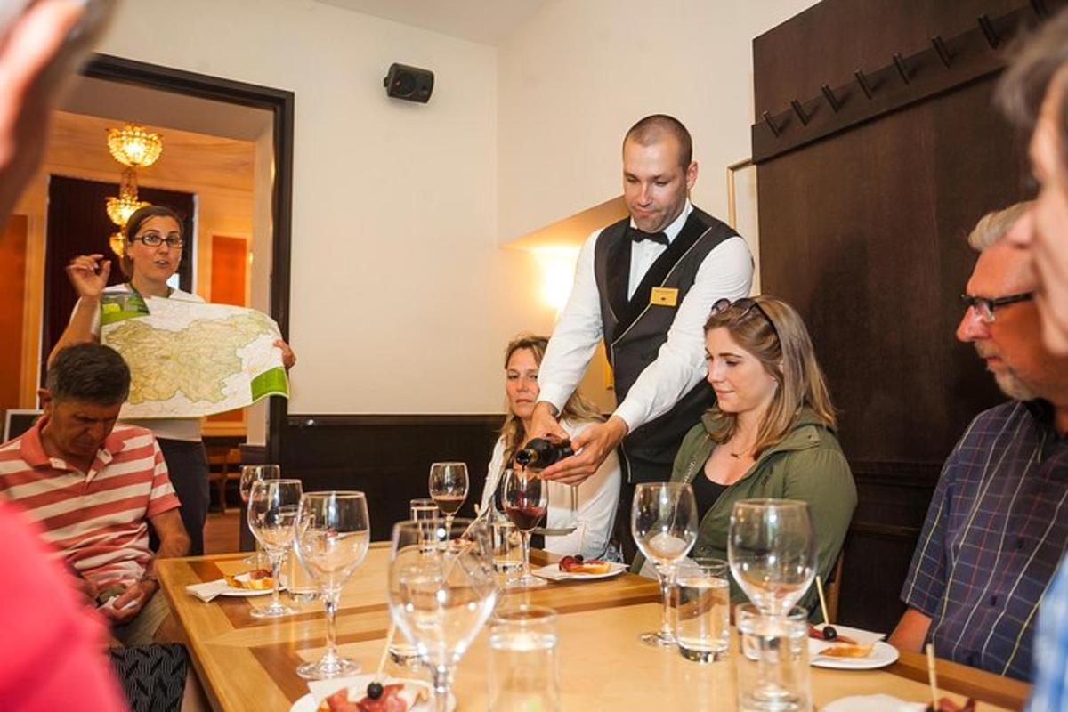 a man holding a bottle of wine at a table