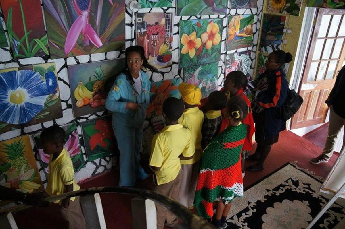 Un grupo de niños de pie en una habitación con una mujer.