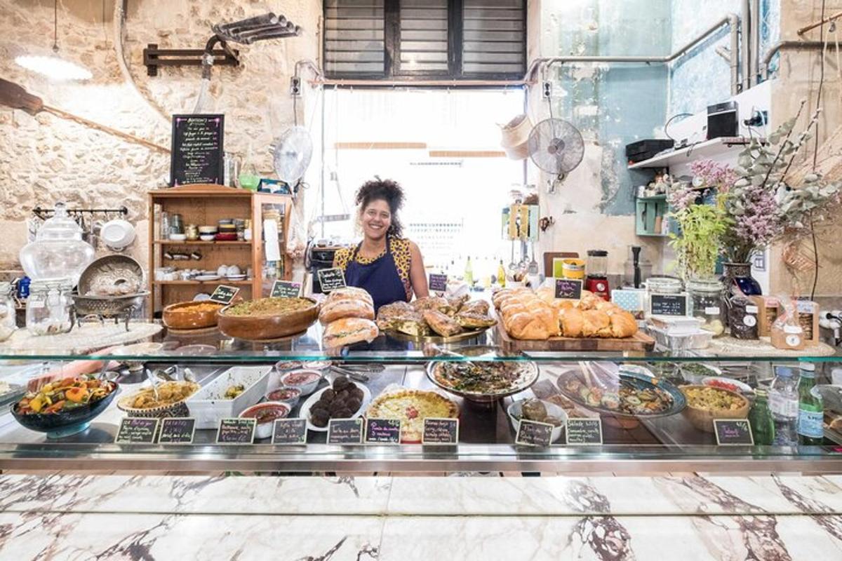 a woman behind the counter of a bakery