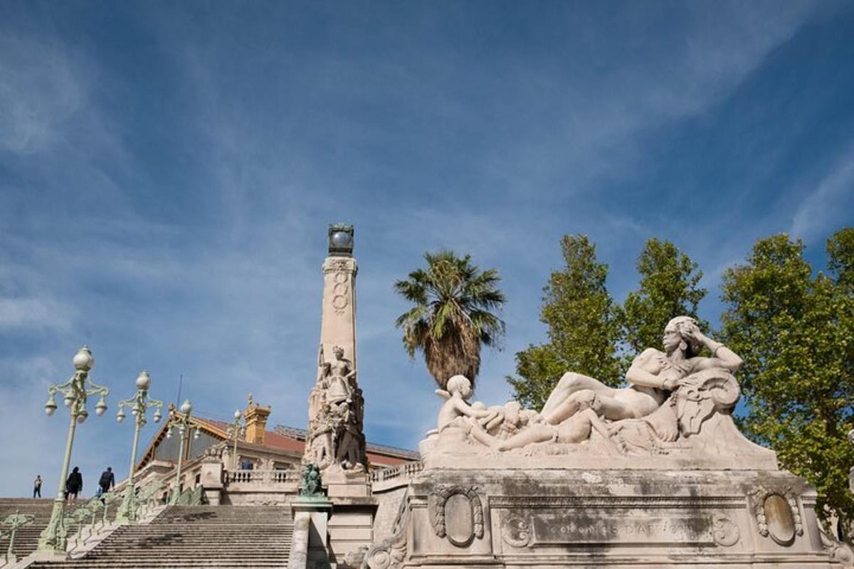 a statue in front of a building with stairs and a tree