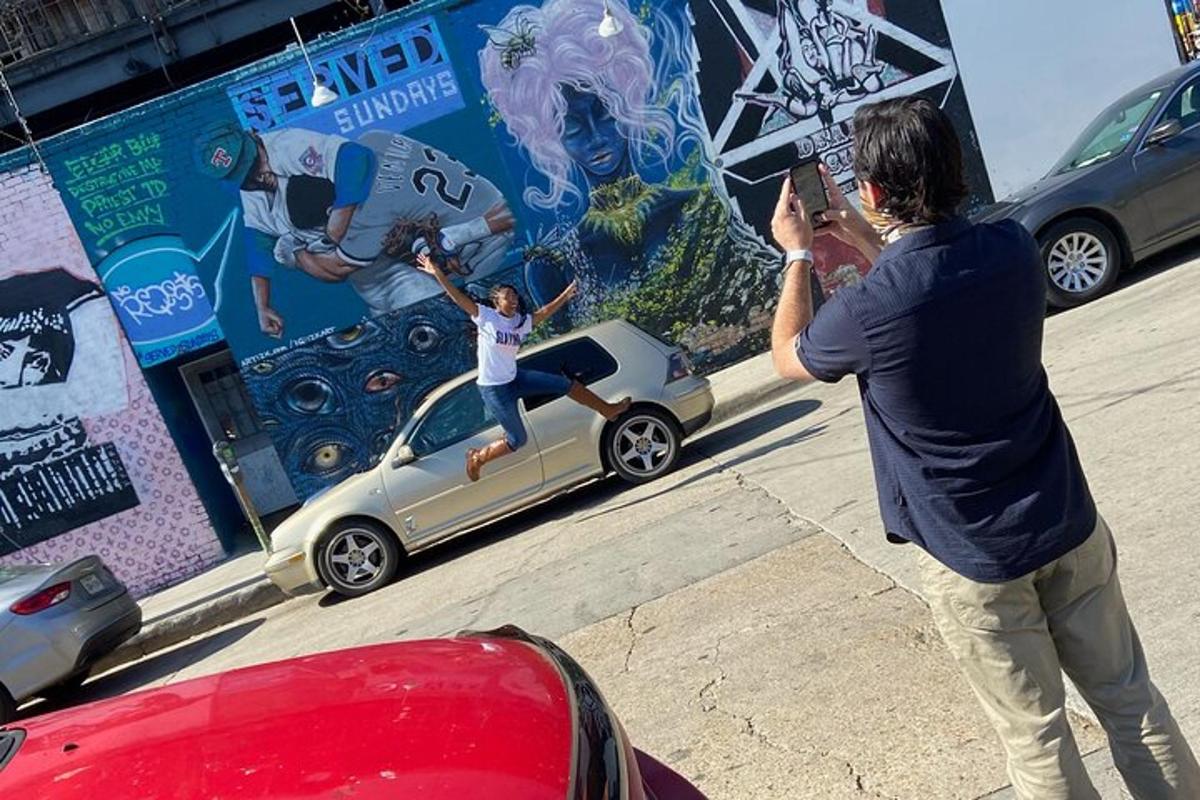 a man taking a picture of a woman jumping off a car