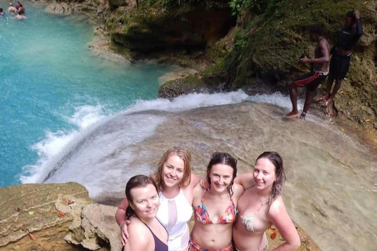 quattro ragazze in costume da bagno in piedi su una roccia in un fiume