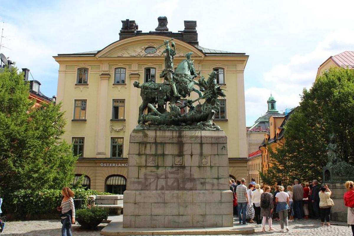 folk står omkring en statue foran en bygning