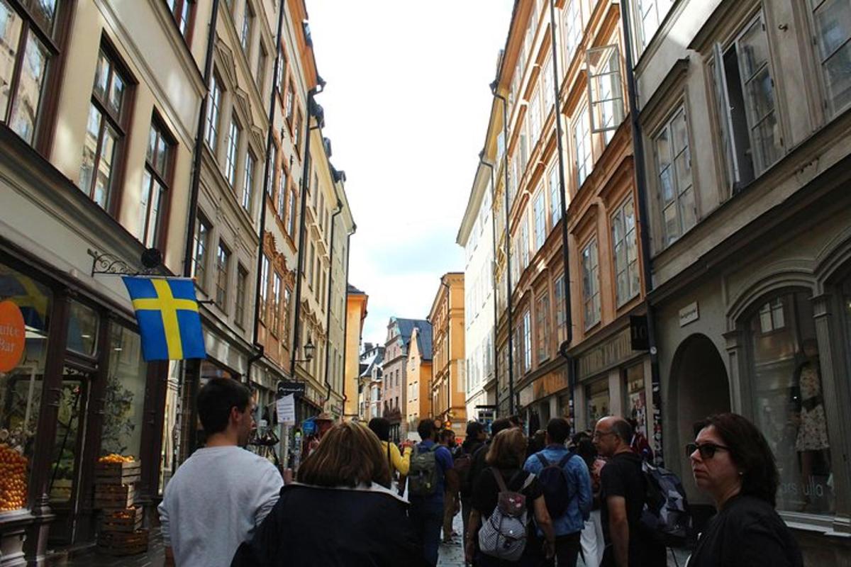 en gruppe mennesker, der går ned ad en gade med bygninger