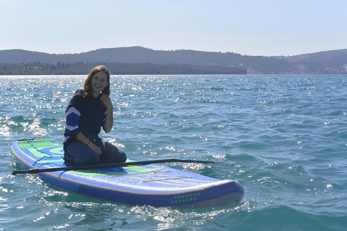 žena sedící na paddleboardu ve vodě