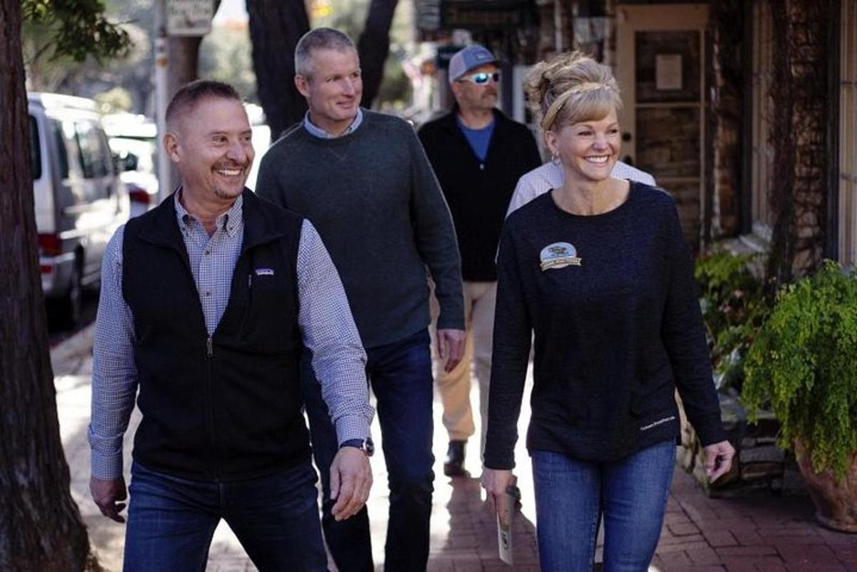 a group of people walking down a sidewalk