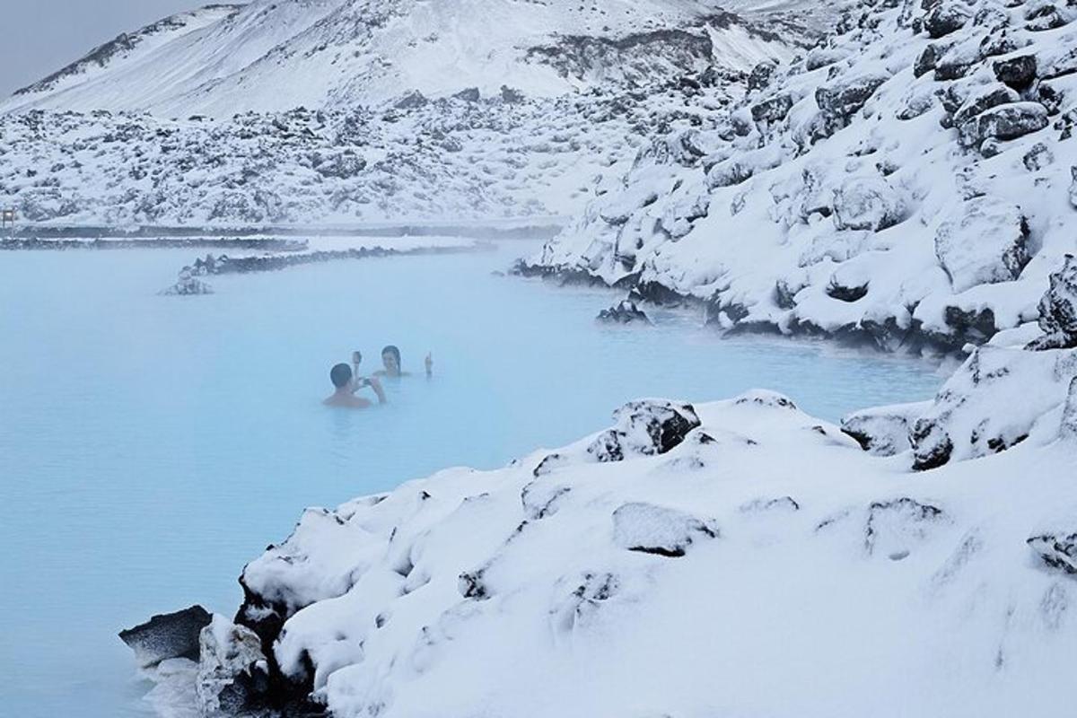 Blár vatnspollur með fólki í snjónum