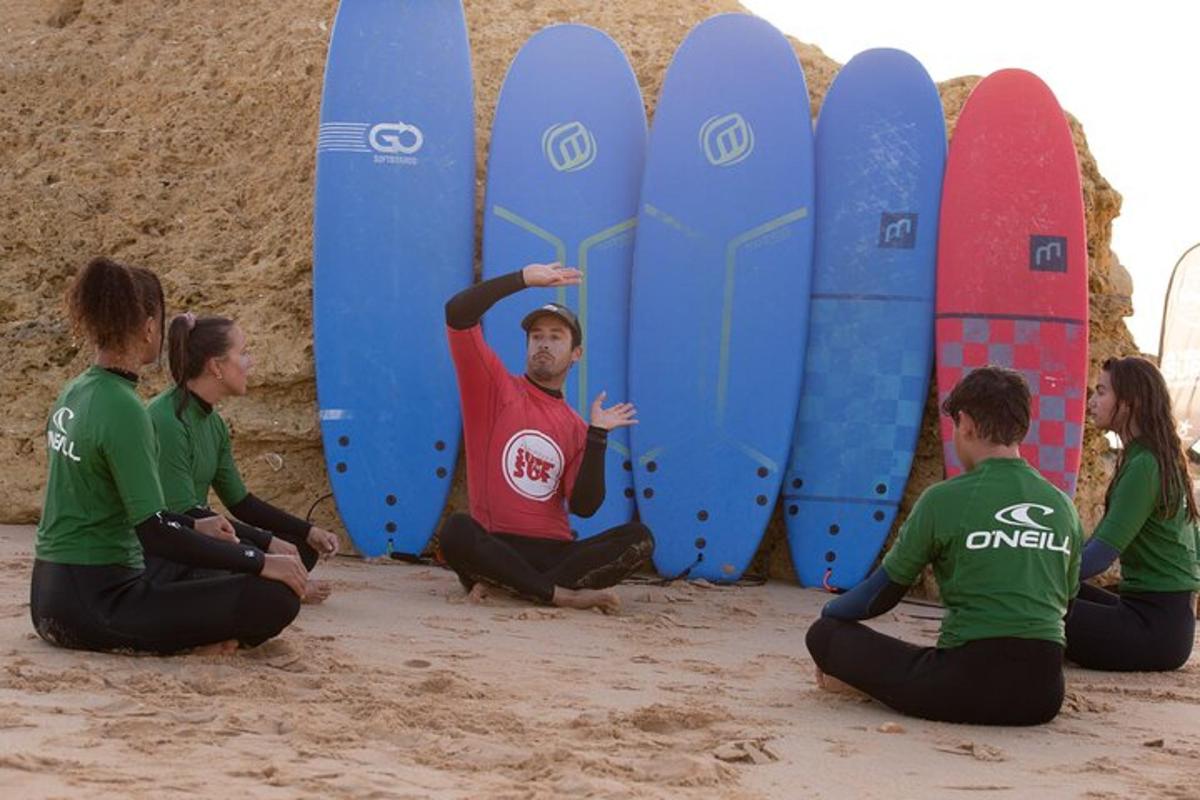sekelompok orang duduk di pantai dengan papan selancar