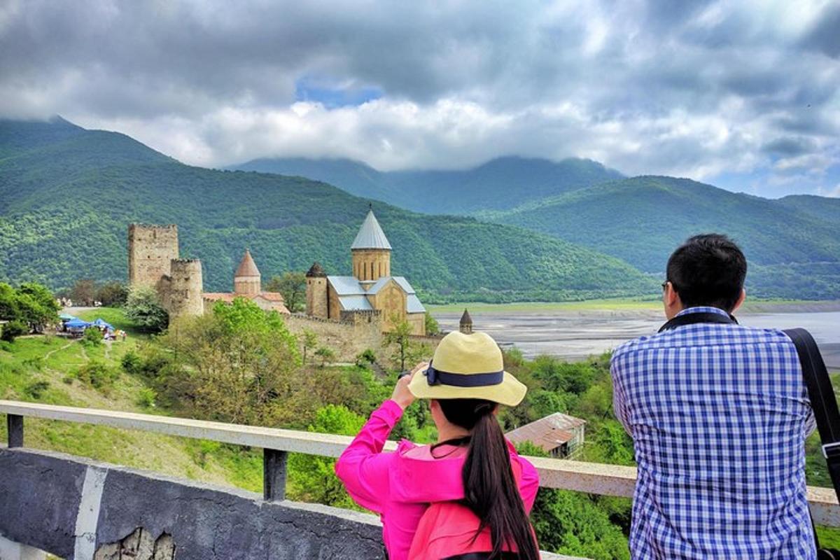 un home i una dona drets en una tanca mirant un castell