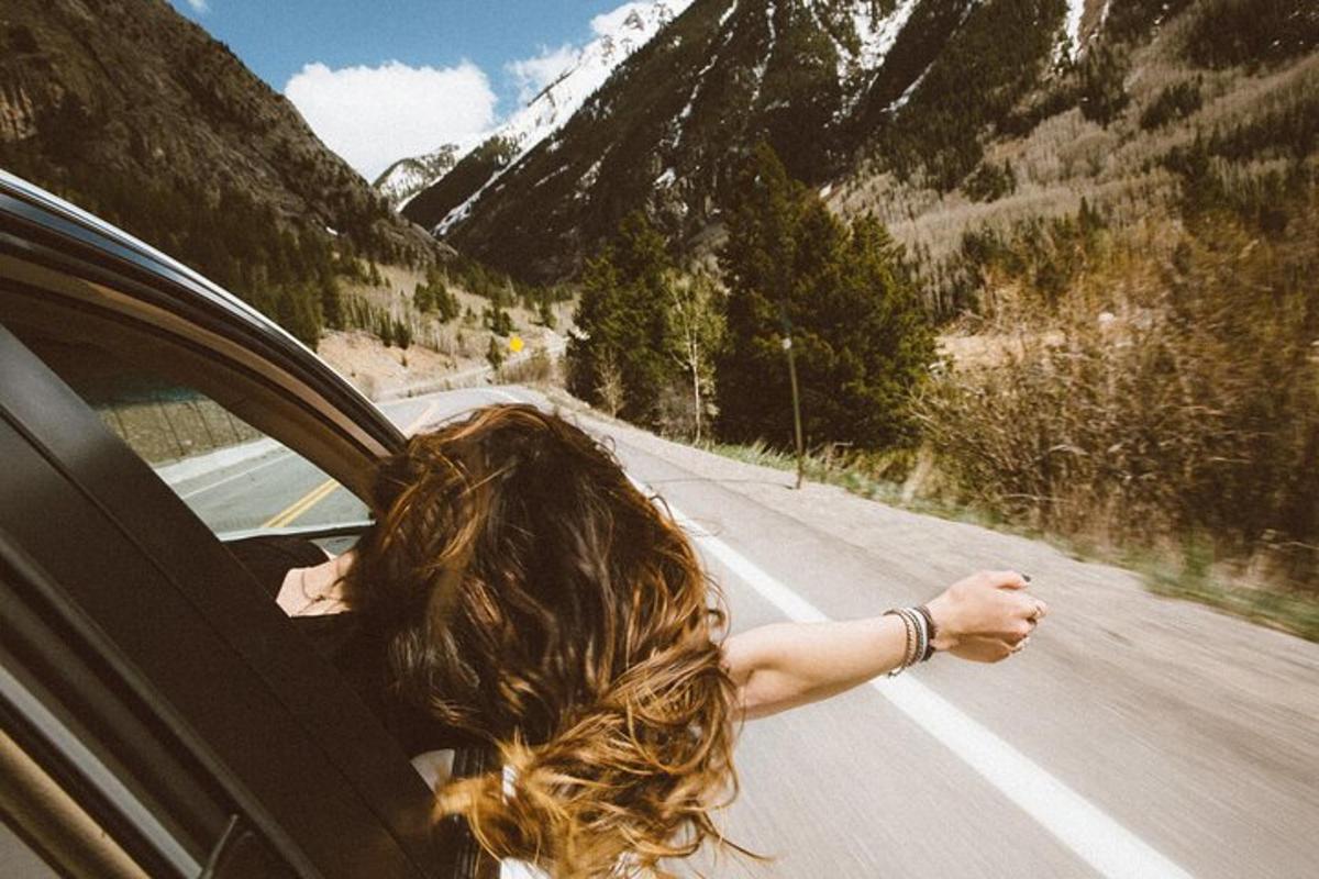 una dona conduint un cotxe per una carretera de muntanya