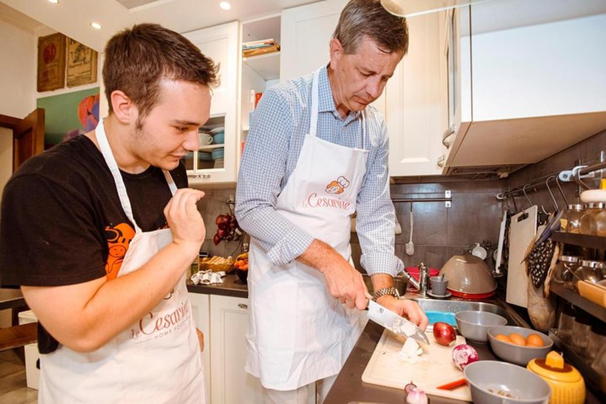 two men standing in a kitchen preparing food