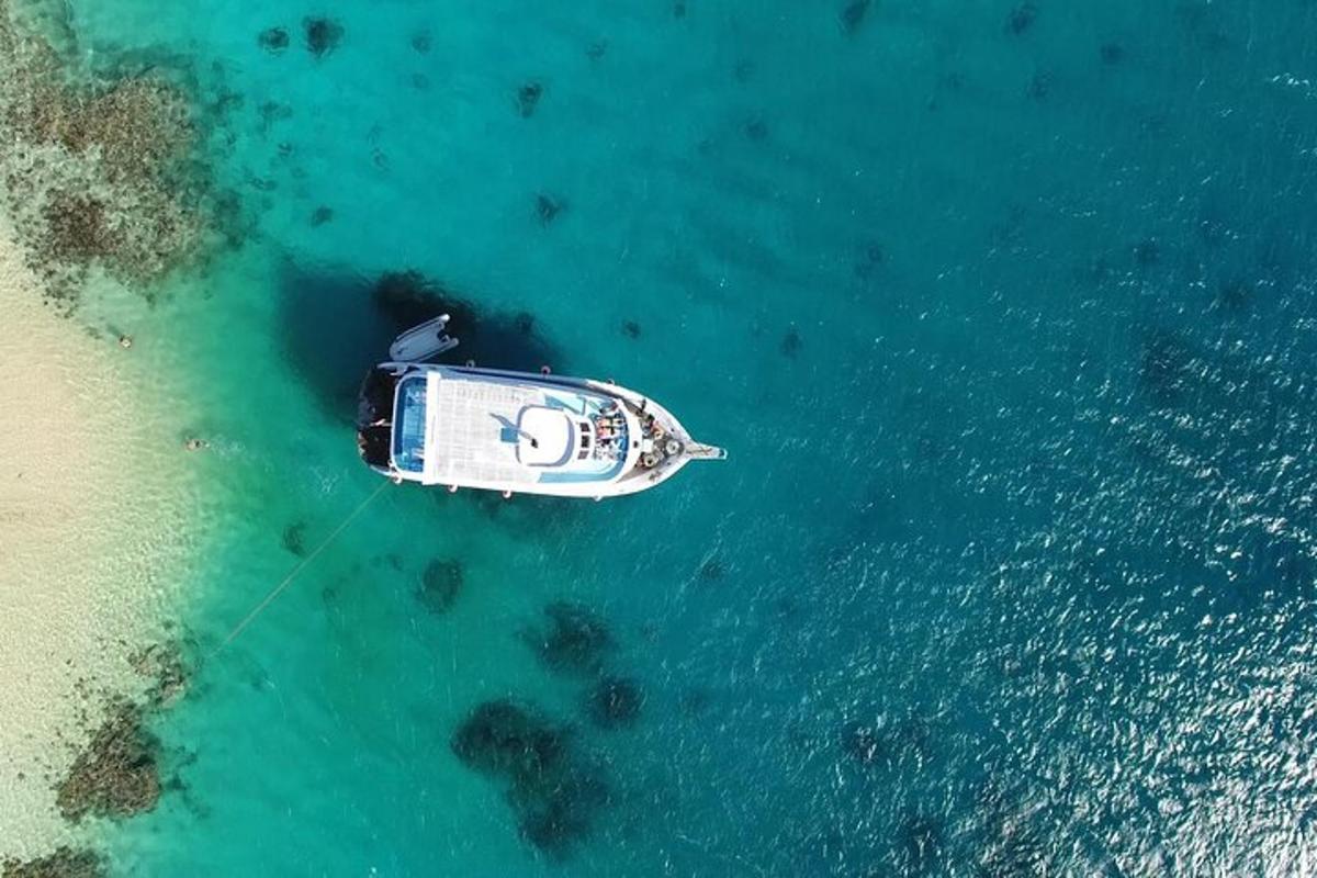 en båd, der flyder i vandet ved siden af en strand
