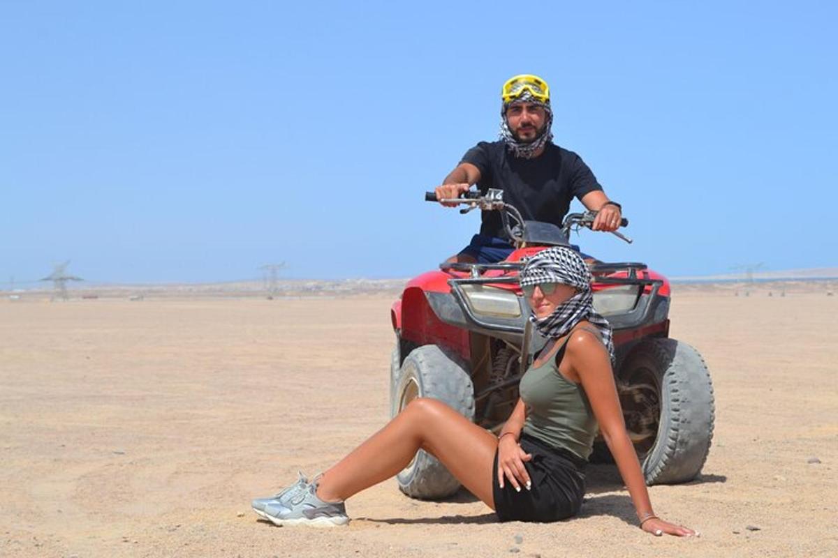 een man en een vrouw op een ATV in de woestijn