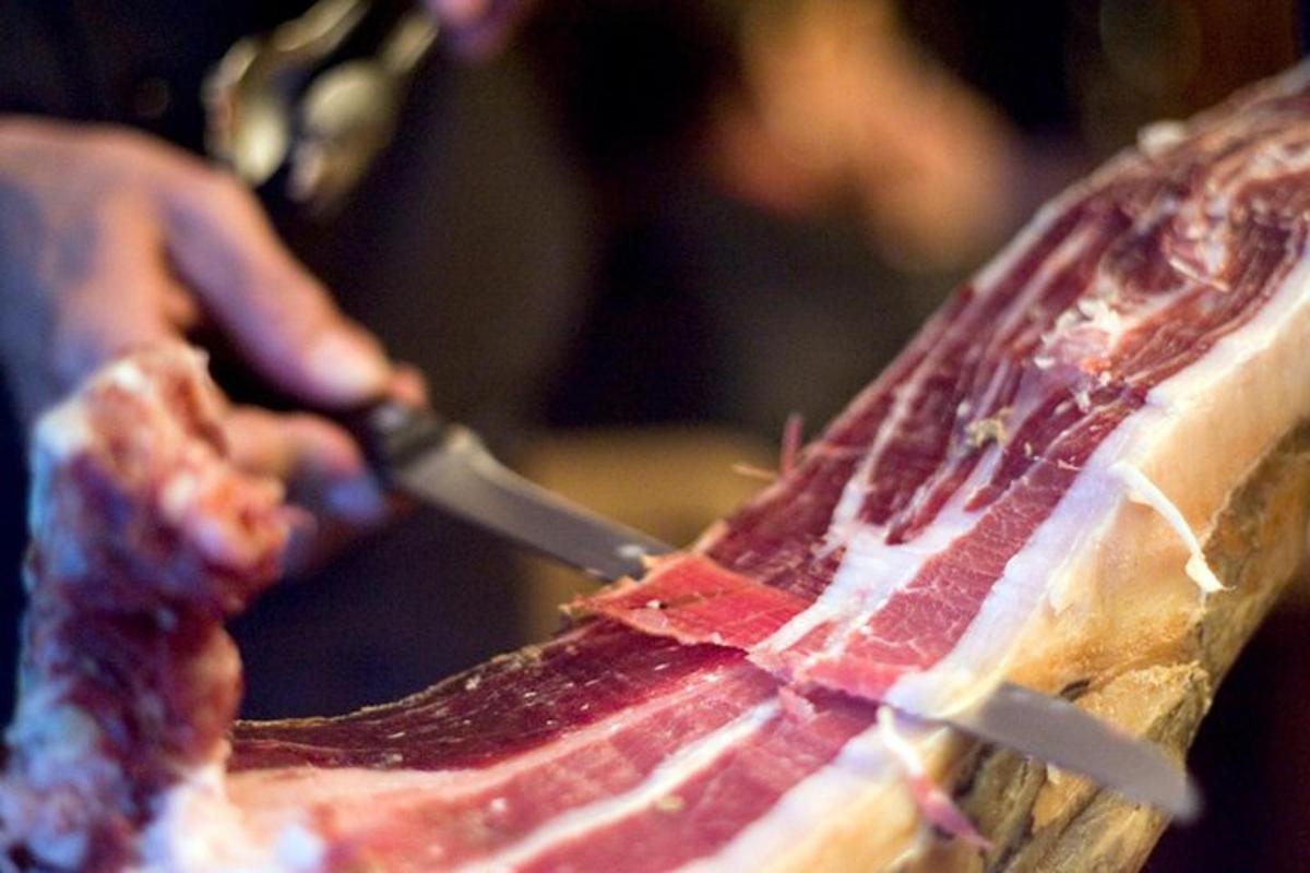 một người đang cắt một miếng thịt bằng dao