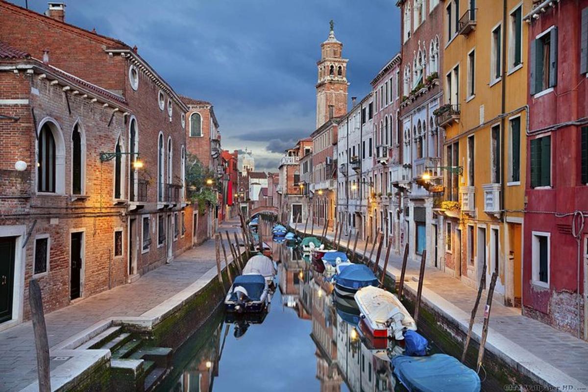 a canal with boats in a city with buildings
