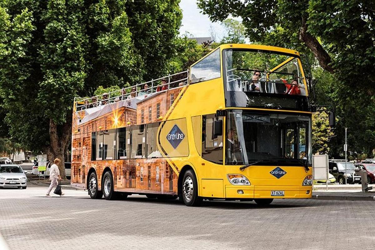 um ônibus amarelo de dois andares passando por uma rua