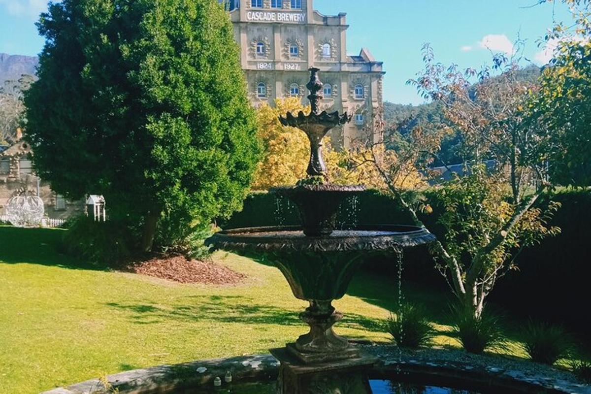 una fontana in un parco con un grande edificio sullo sfondo
