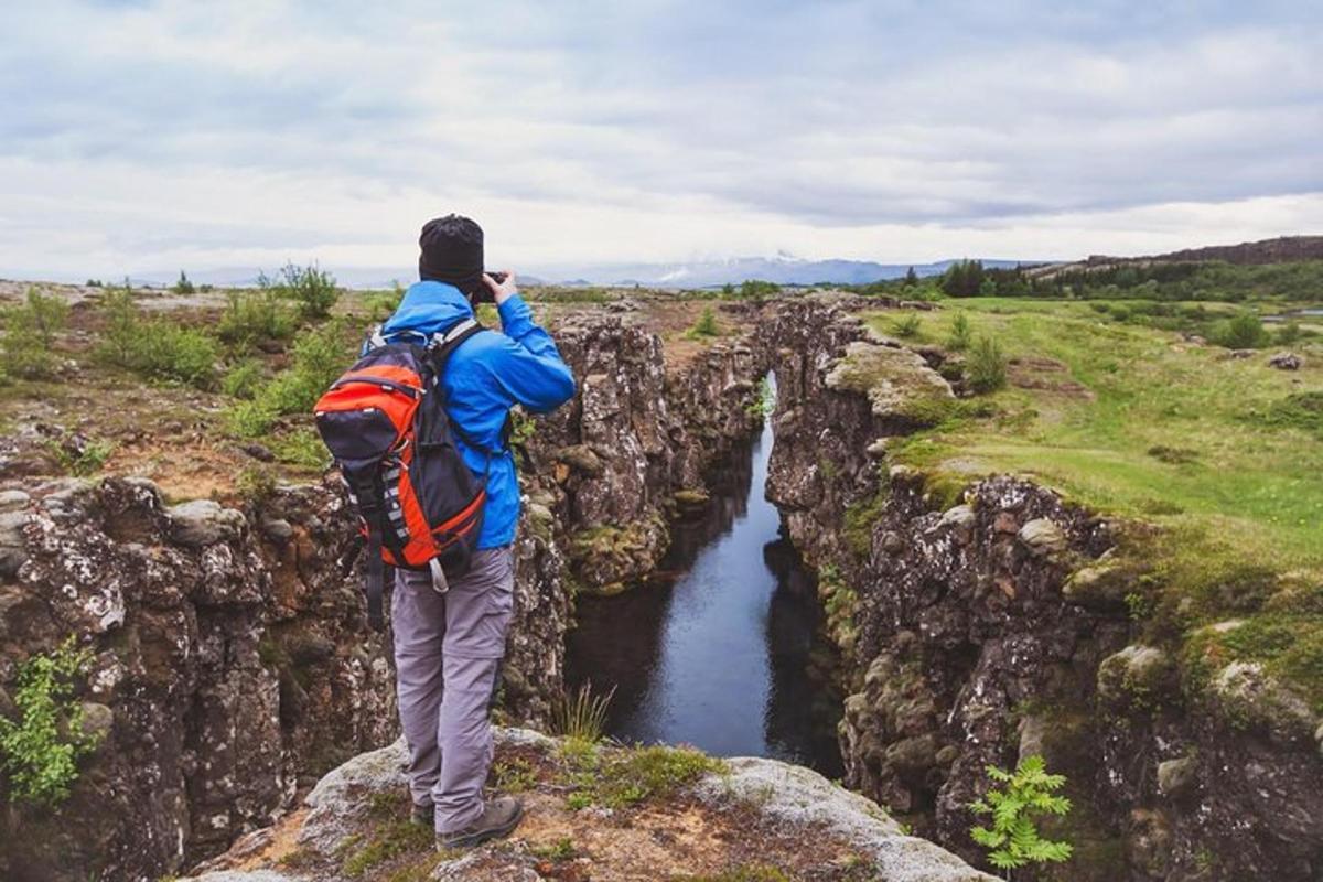 un uomo in piedi su una scogliera che guarda un fiume
