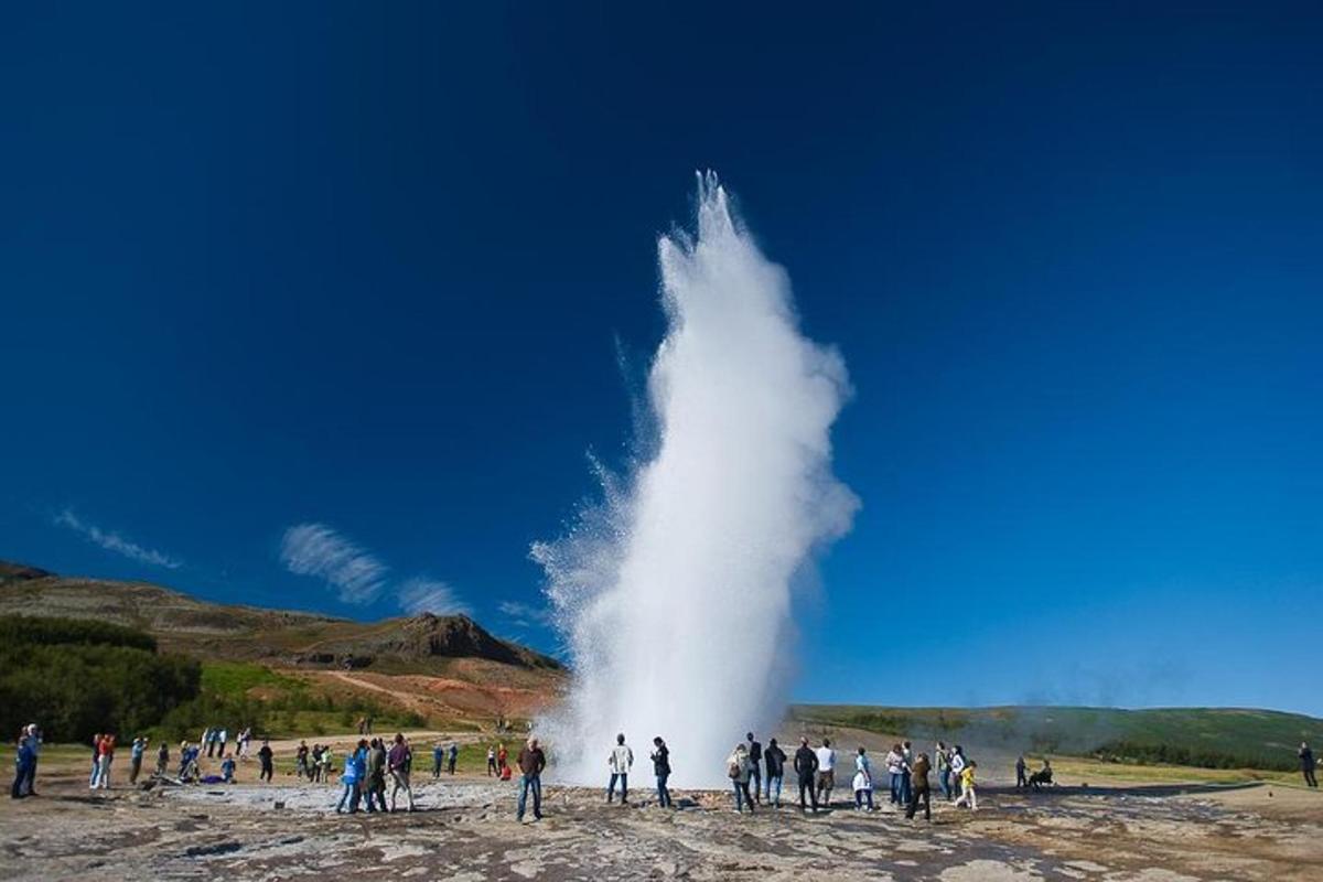 un gruppo di persone in piedi attorno a un geyser