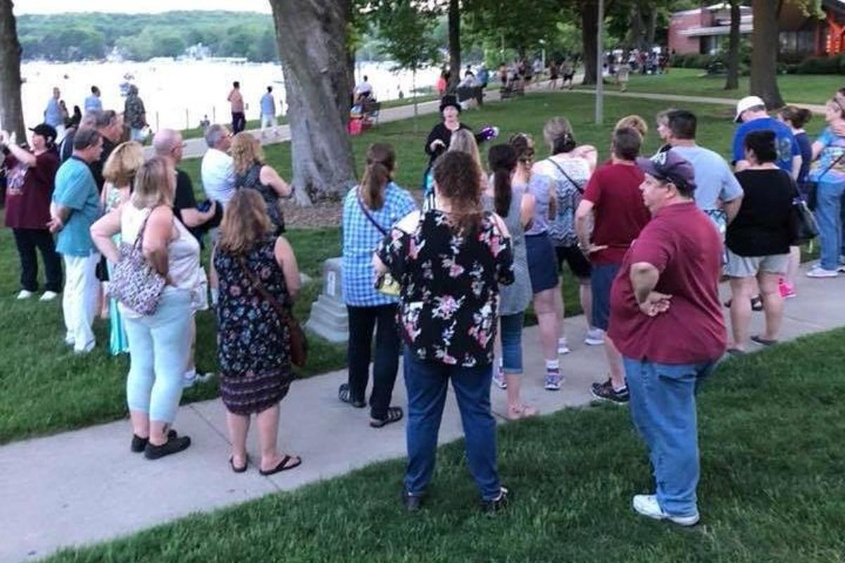 a group of people standing around in a park