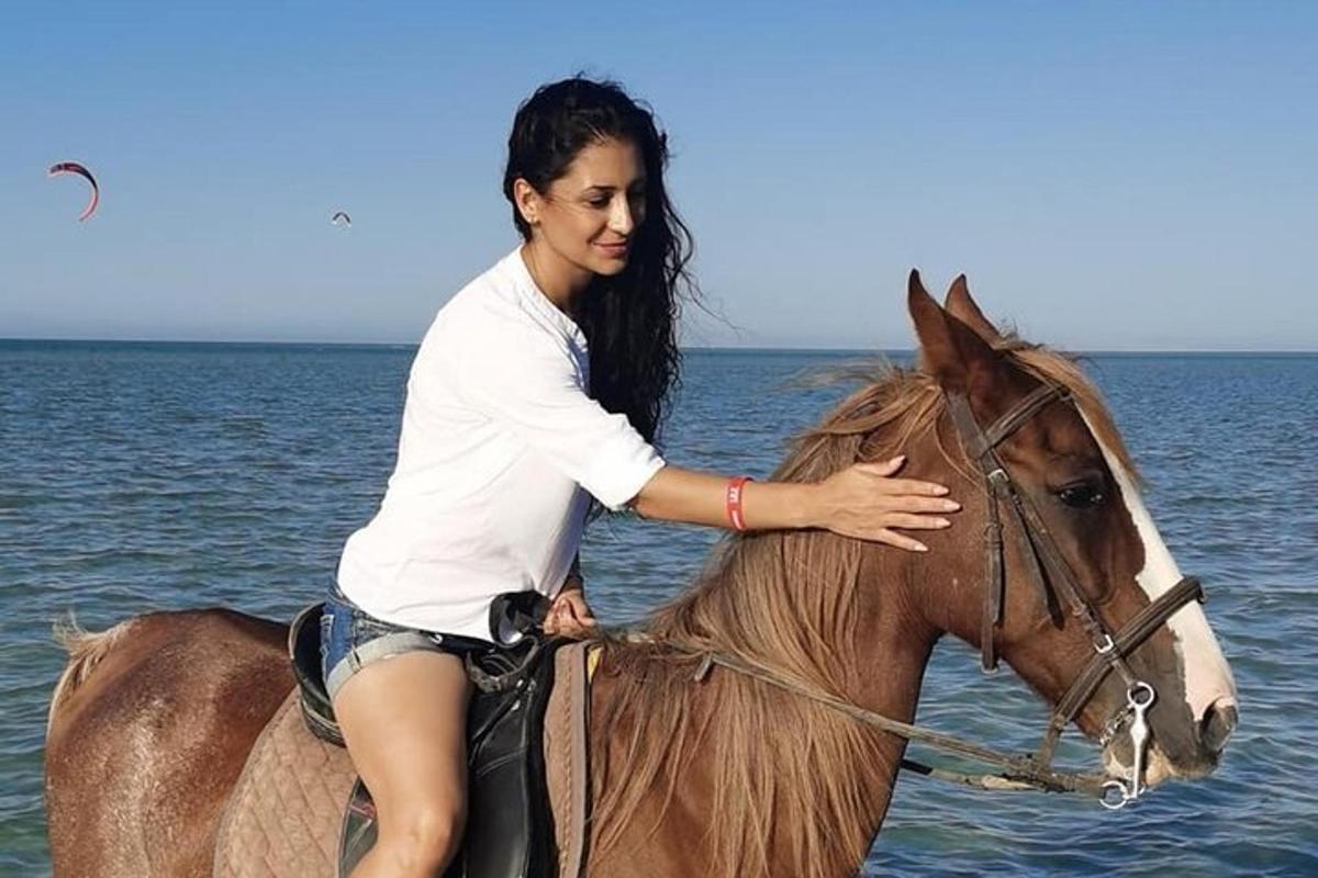 žena jedoucí na koni ve vodě