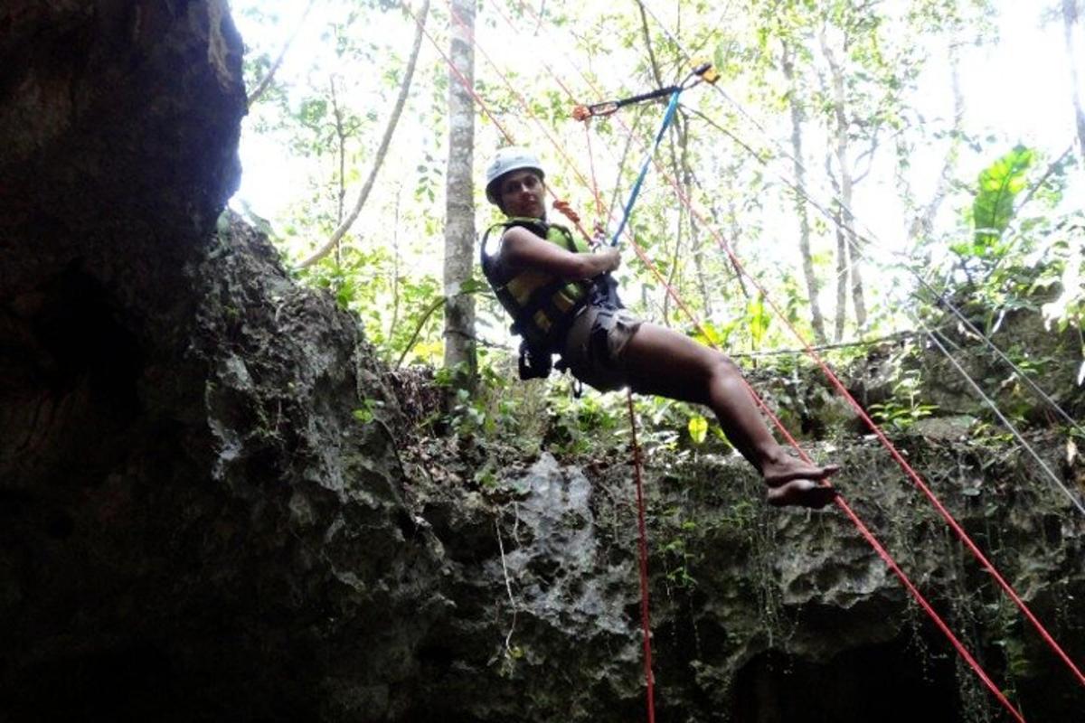 Un hombre está colgado de una cuerda en la jungla.