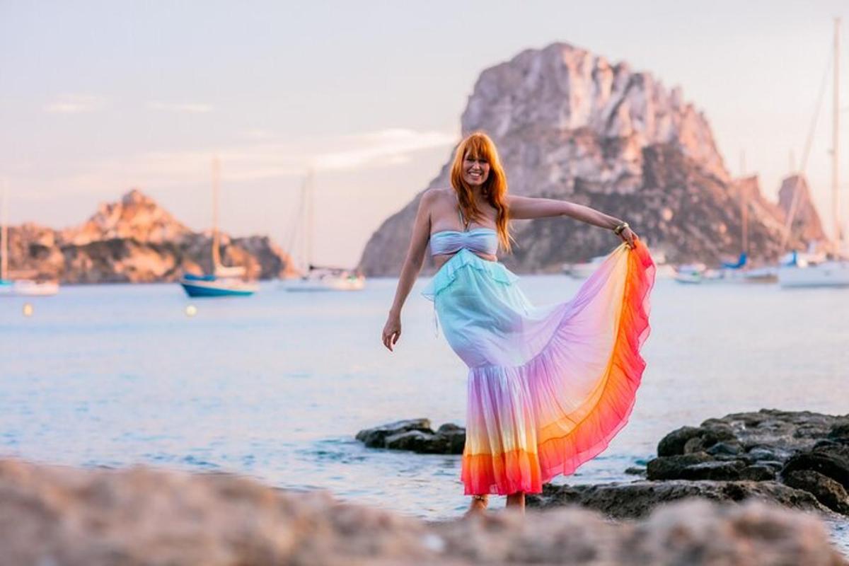 a woman in a dress standing on the beach