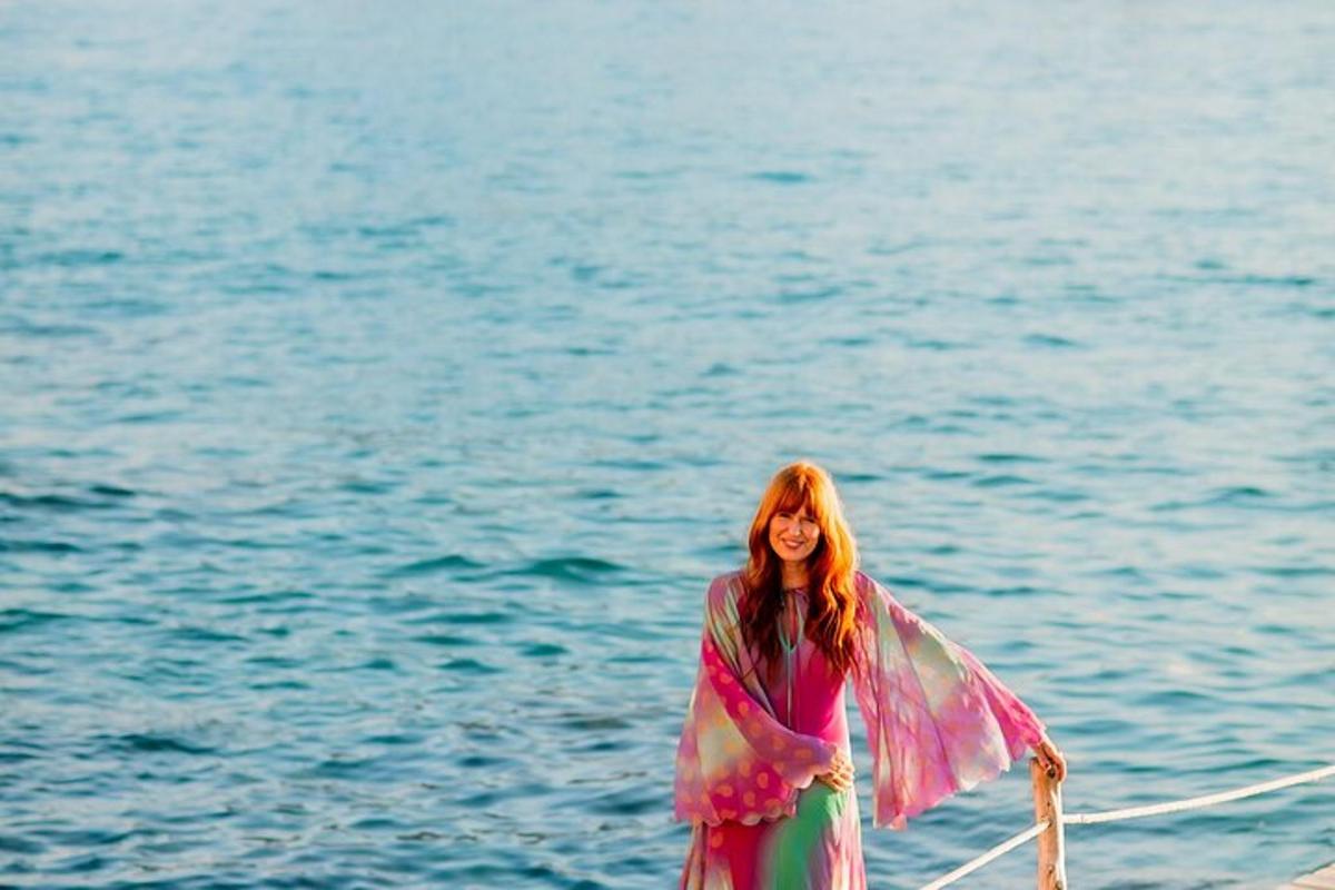 a woman in a dress standing next to the water