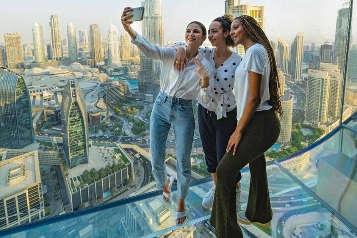 three girls taking a picture on top of a skyscraper