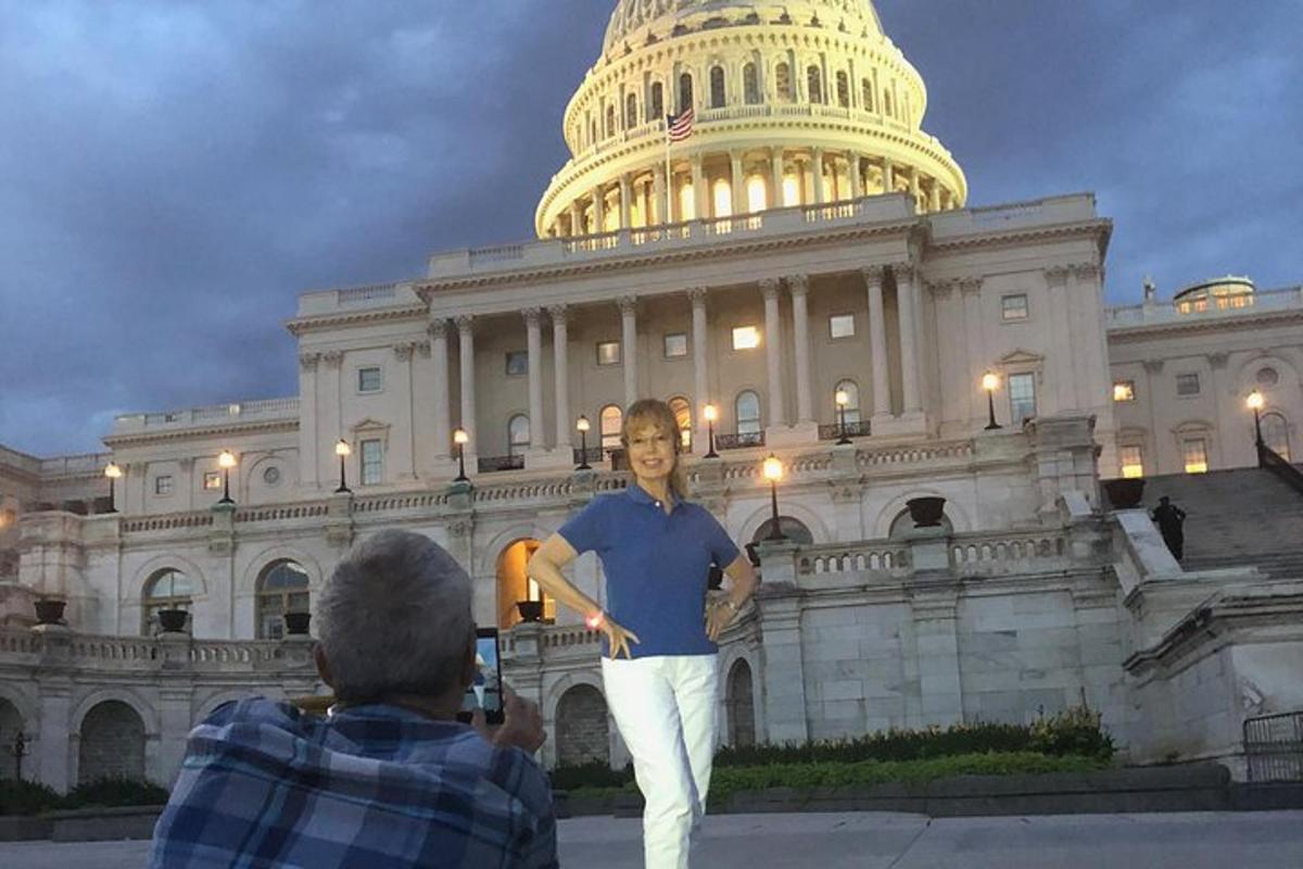 a man taking a picture in front of the us capitol building