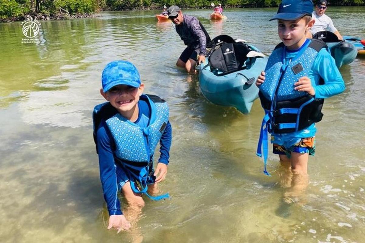 two young boys wearing life jackets in the water