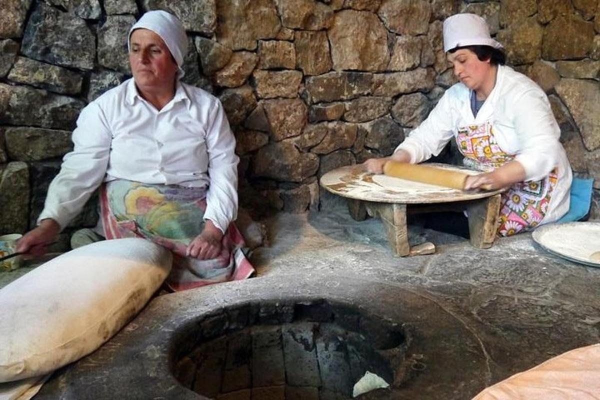 un paio di persone sedute attorno a un forno di pietra