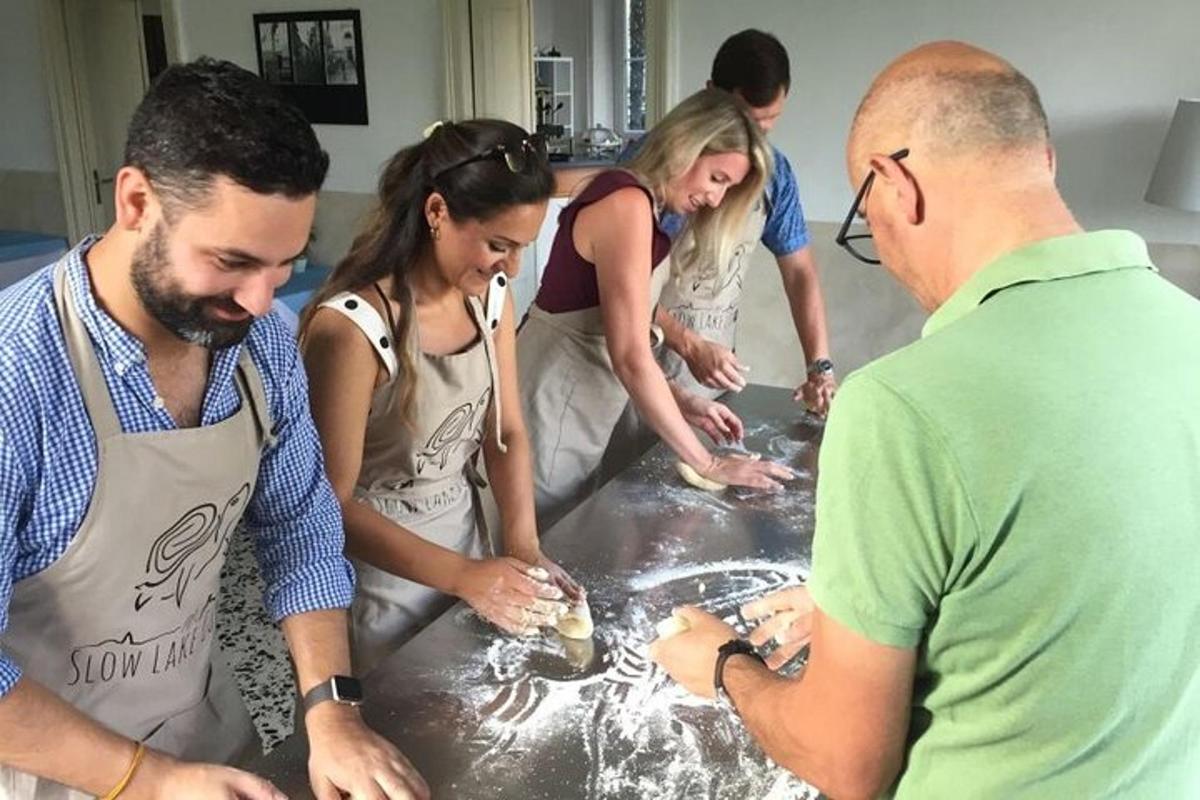 een groep mensen die rond een tafel staan en eten bereiden