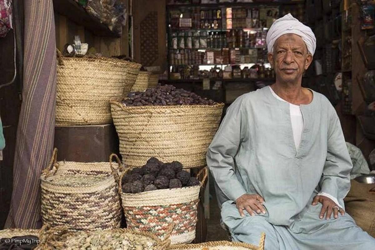 a man sitting in front of baskets of fruit